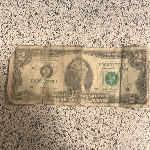 2 dollar bill old an a little damaged from being in wallet